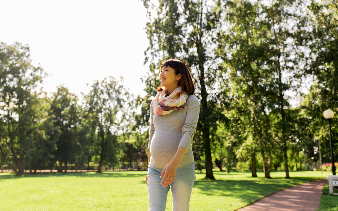 Pregnant woman walking calmly through a park